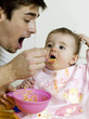 Father feeding baby girl