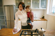 Mother carrying daughter while writing