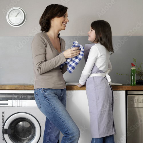 Foto: Mother and daughter washing the dishes together Mother and daughter washing the dishes together