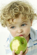 Boy eating green apple