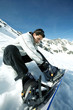 Male snowboarder strapping board onto feet
