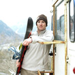 Man in warm clothing holding snowboard