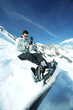 Male snowboarder adjusting his glove