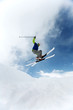 Man doing a mid air ski jump off a mountain 