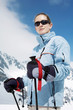 Woman with sunglasses holding on skiing poles