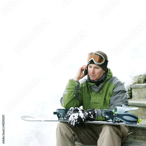 Photo: Male snowboarder talking on the phone Male snowboarder talking on the phone