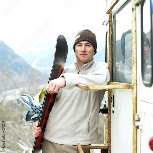 Photo: Man in warm clothing holding snowboard Man in warm clothing holding snowboard