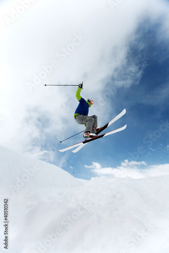 Photo: Man doing a mid air ski jump off a mountain Man doing a mid air ski jump off a mountain