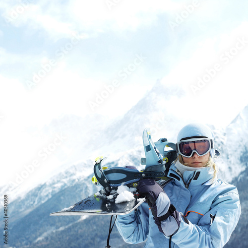 Photo: Woman in ski goggles holding snowboard Woman in ski goggles holding snowboard