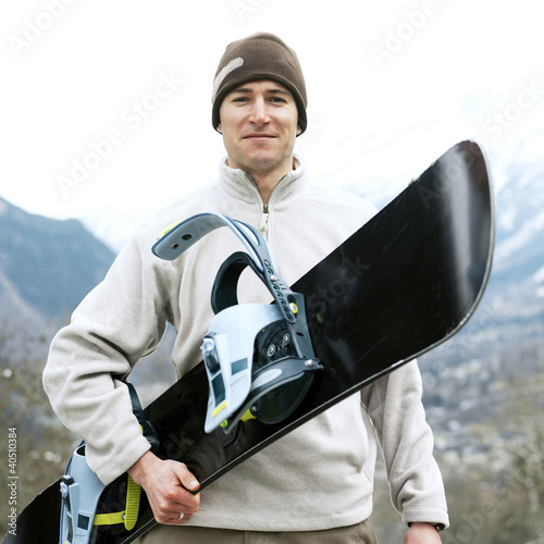 Photo: Man in warm clothing holding snowboard Man in warm clothing holding snowboard