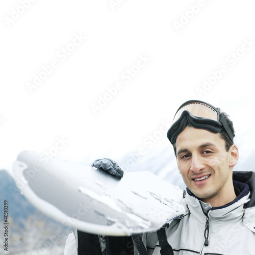 Photo: Man in warm clothing holding ski board Man in warm clothing holding ski board