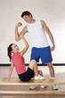 Man flexing his muscle, woman winking while touching his muscle