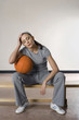 Woman sitting on bench with a basketball