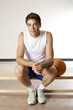 Man sitting on bench, basketball beside him