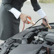 Businesswoman using jumper cables