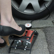 Businesswoman stepping on air pump