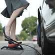 Businesswoman stepping on air pump