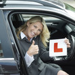 Businesswoman showing thumbs up while holding L plate