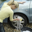 Woman washing car wheel