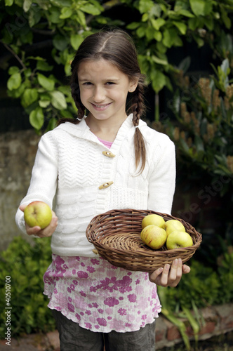 Photo: Girl holding a basket of apples Girl holding a basket of apples