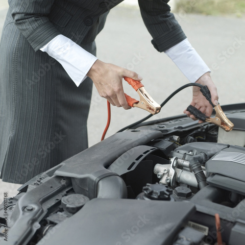 Foto: Businesswoman using jumper cables Businesswoman using jumper cables