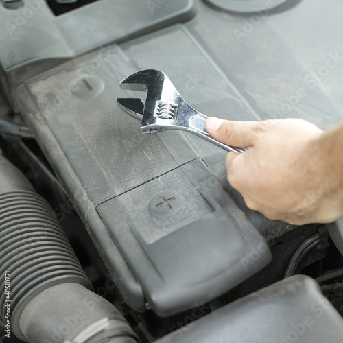 Photo: Guy's hand holding an adjustable wrench Guy's hand holding an adjustable wrench