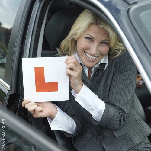 Foto: Businessman smiling while holding L plate Businessman smiling while holding L plate