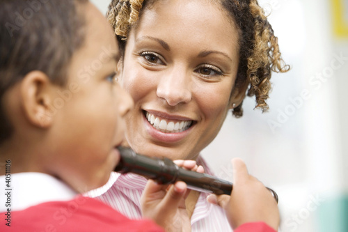 Photo: Woman teaching boy to play recorder Woman teaching boy to play recorder
