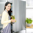 Foto: Woman taking out asparagus from the refrigerator Woman taking out asparagus from the refrigerator