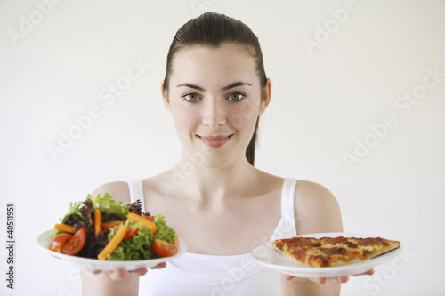 Photo: Woman holding pizza and salad Woman holding pizza and salad