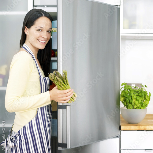 Foto: Woman taking out asparagus from the refrigerator Woman taking out asparagus from the refrigerator