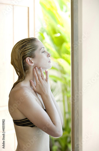 Photo: Woman applying body lotion Woman applying body lotion