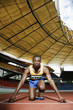Foto: Man in starting position on running track Man in starting position on running track