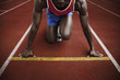 Foto: Man in starting position on running track Man in starting position on running track