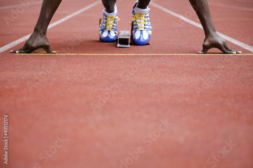 Photo: Man in starting position on running track Man in starting position on running track