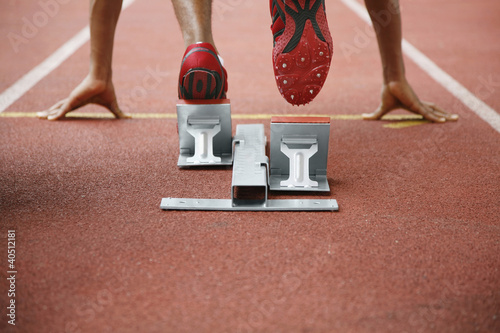 Photo: Man in starting position on running track Man in starting position on running track