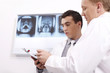 Doctors discussing while looking at papers on clipboard