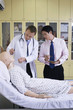 Doctors examining dummy patient on the bed