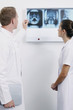 Doctor explaining to nurse while pointing at X-ray image