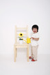 Boy holding a watering can about to water the sunflower