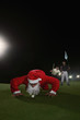 Man in santa suit blowing golf ball into hole with two men cheering in the background