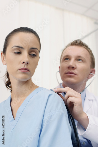 Photo: Doctor examining patient using stethoscope Doctor examining patient using stethoscope