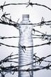 Plastic bottle surrounded by barbed wire