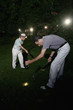 Two men searching for golf ball at night