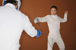 Woman with fencing foil dodging her opponent's attack