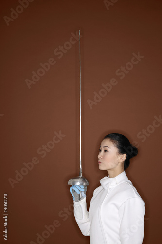 Photo: Woman in fencing suit with fencing foil Woman in fencing suit with fencing foil