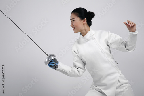 Foto: Woman in fencing suit with fencing foil Woman in fencing suit with fencing foil