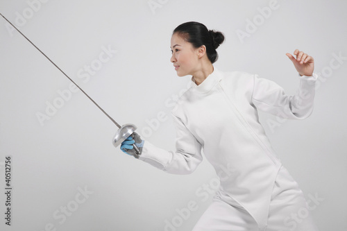 Foto: Woman in fencing suit with fencing foil Woman in fencing suit with fencing foil