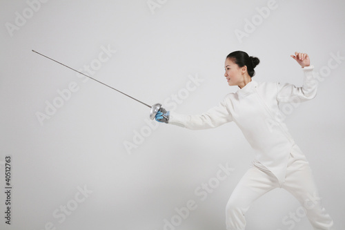 Photo: Woman in fencing suit with fencing foil Woman in fencing suit with fencing foil