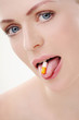 Woman showing pill on her tongue
